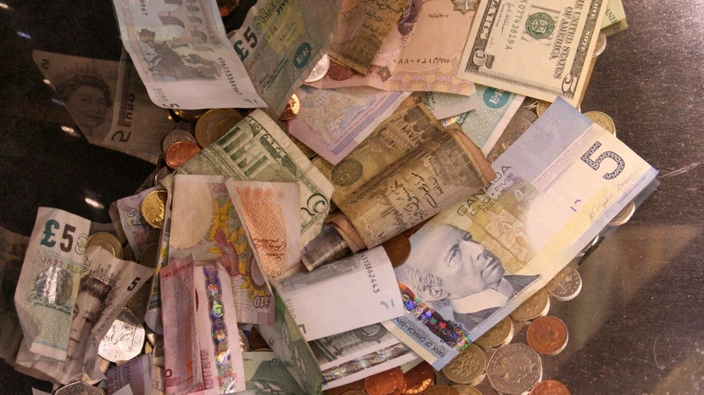 different countries' money in a collection container